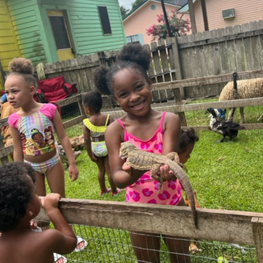 Small children playing with a lizard.